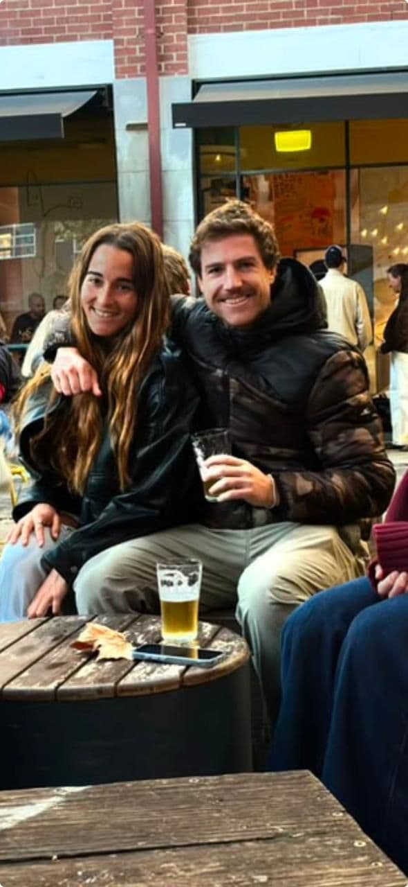 Cristian and his partner at an outdoor table with friends